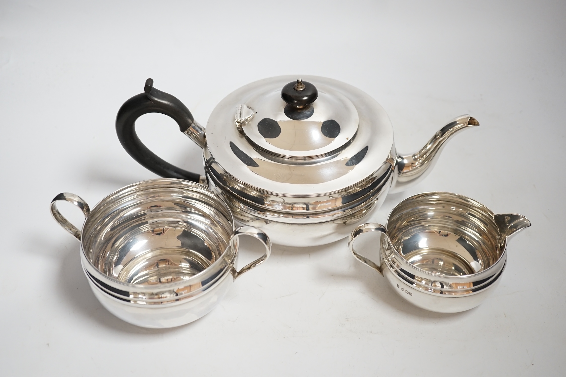 A George V silver three piece circular tea set, with banded girdle, Cooper Brothers & Sons, Sheffield, 1931, 26oz.